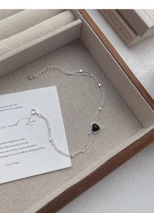 Macro shot of S925 sterling silver double-layer bracelet with black heart charm