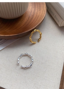 Detailed macro view of S925 sterling silver knotted rings in gold and silver finishes