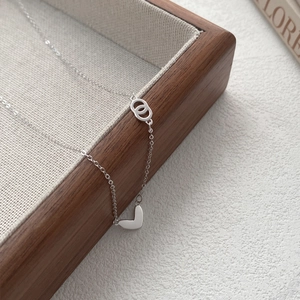Minimalist S999 sterling silver heart and double-loop necklace on wooden tray