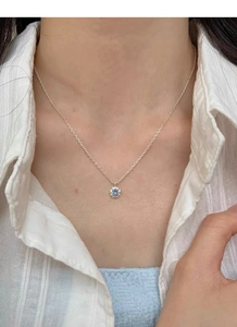 Vue détaillée d'un pendentif fleur en zircon bleu sur une chaîne en argent sterling S925
