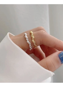 Detail of twisted knot S925 sterling silver rings in gold and silver finish on hand