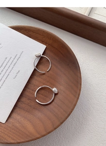 Close-up of S925 sterling silver adjustable rings with white pearls on a wooden tray