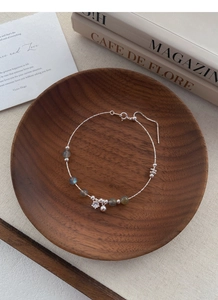 Close-up of S925 silver beaded bracelet with labradorite gems and star pendant on wood