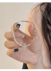 Detail of S925 silver bracelet featuring mixed tourmaline beads and floral clover charm