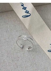 Detail macro-opname van S925 zilveren dubbele ring met zirkoon en kralenstructuur