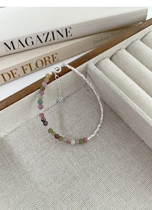 Detailed macro view of colorful tourmaline beads with S925 silver clasp and heart pendant