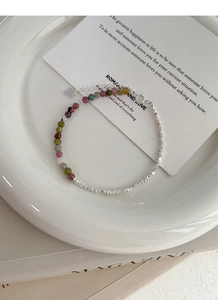 Macro detail of multi-color beads and silver charms bracelet with a heart pendant