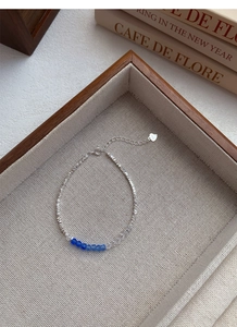 Detail of S925 sterling silver beaded bracelet with blue crystals on a wooden tray
