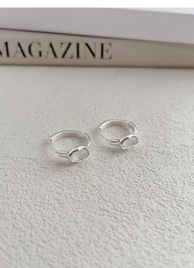 Close-up of S925 sterling silver hoop earrings with iridescent moonstone charms
