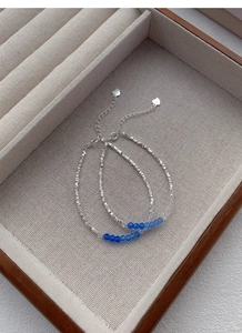 Detailed macro view of S925 sterling silver bracelets with blue crystals and heart pendant