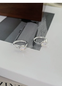 Macro detail of S925 sterling silver hoop earrings with iridescent moonstone inlay
