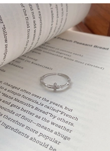 Detailed macro view of S925 sterling silver cross ring with white zircon on vintage book