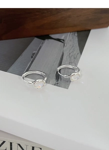Detail of S925 sterling silver hoop earrings featuring oval moonstone on white surface