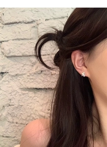 Gros plan d'un clou d'oreille étoile en argent S999 porté par un mannequin en gros plan