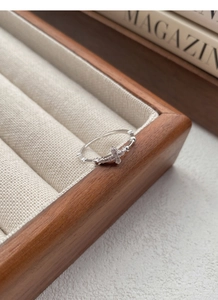Macro detail of S925 sterling silver cross ring with pavé zircons on a wooden jewelry box