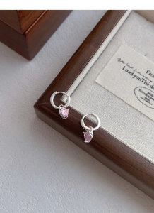 Détail de boucles d'oreilles cœur en argent S999 avec zircon rose sur boîte bois