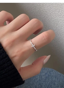 Close-up of minimalist S925 sterling silver cross ring with pavé micro-zircons on index finger