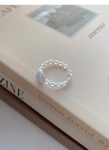 Dettaglio dell'anello in argento 925 con pietra di luna luminosa su un libro