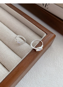 Detailed macro view of S925 sterling silver hoop earrings with oval moonstone inlay