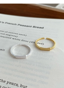 Detail view of gold and silver S925 sterling silver open rings on vintage paper