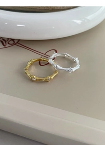 Macro shot of silver and gold bamboo texture rings with sparkling zircon inlay detail