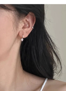 Gros plan de boucles d'oreilles cœur rose et d'un faux piercing étoile sur un mannequin