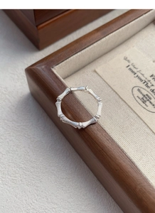 Detail of S925 silver bamboo-style ring with sparkling zircon stones on a jewelry box