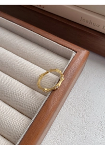 Macro detail of gold bamboo joint ring with sparkling zircons on jewelry box display