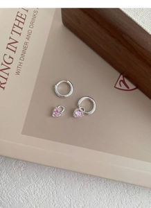 Détails macro de créoles en argent avec pendentif cœur amovible en zircon rose
