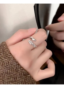 Detail of S925 sterling silver snake-shaped open ring with cubic zirconia clusters on hand