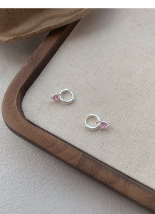 Vue détaillée des boucles d'oreilles en argent S999 avec pendentifs cœur rose en zircon