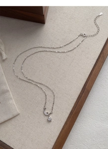 Nahaufnahme der S925 Silber Stern- und Mondkette mit Zirkonia auf Leinenuntergrund