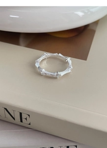 Macro shot of silver bamboo joint ring with sparkling zircons on elegant book