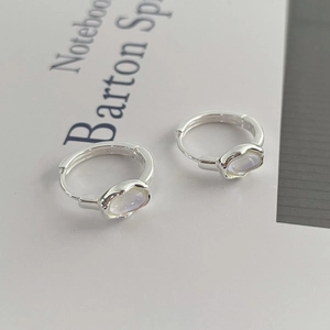 S925 sterling silver hoop earrings with oval rainbow moonstones on a white notebook