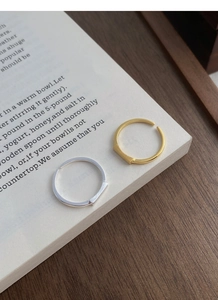 Artistic detail of gold and silver rectangular open rings on vintage book pages