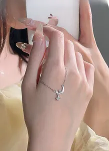 Makroaufnahme von S999 Sterlingsilber Mondsichel und Sternanhänger an feiner Kette