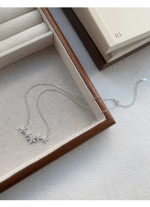 Dettaglio della collana floreale in argento con cinque ciondoli in zircone su legno