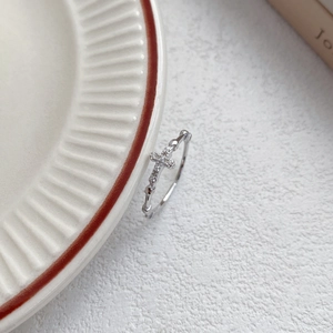 Minimalist S925 sterling silver cross ring with cubic zirconia stones on ceramic plate