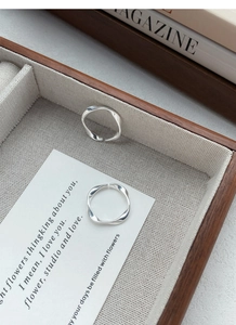 Close-up of S999 sterling silver Mobius rings displayed on a wooden tray and card