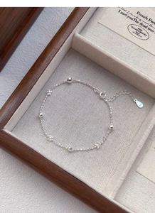 Gros plan d'un bracelet fleur en argent S925 avec perles laser et fermoir ajustable
