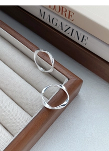 Close-up of S999 silver Mobius ring with wavy polished finish on a velvet display