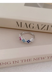 Detailed macro view of silver adjustable ring with colorful four-leaf clover zircon stones