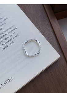 Detailed view of S999 silver Mobius ring with polished finish on a white book page