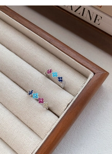 Close-up of S925 sterling silver rings with colorful clover patterns and zircon stones