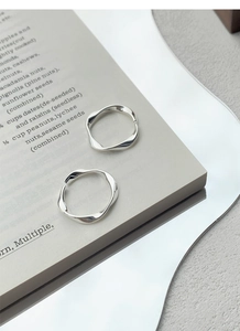 Macro detail of two S999 silver Mobius rings displayed on a luxury mirror tray