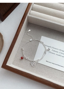 Detail of S925 silver double-layer bracelet with bear charm and red agate bead