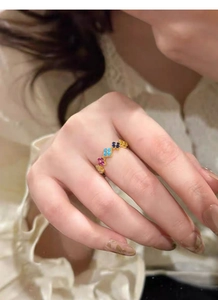 Close-up of S925 silver rainbow clover ring with colorful zircons on a model finger