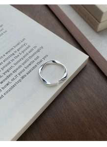 Close-up of S999 sterling silver Mobius ring on an open book showing polished texture