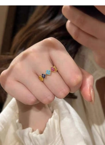 Detail of multi-clover silver ring featuring colorful zircon stones on model's hand