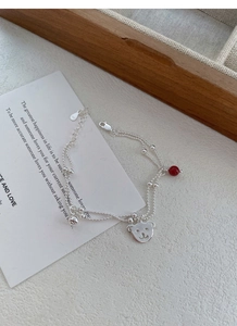 Detail view of S925 sterling silver bear pendant and red agate bead on double-layer chain